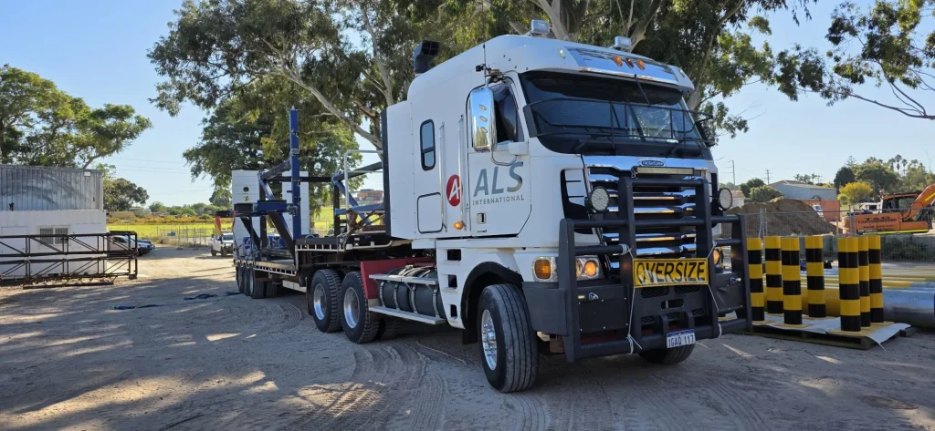 ALS International oversize load — blue structural steel frame on a float with oversize signage