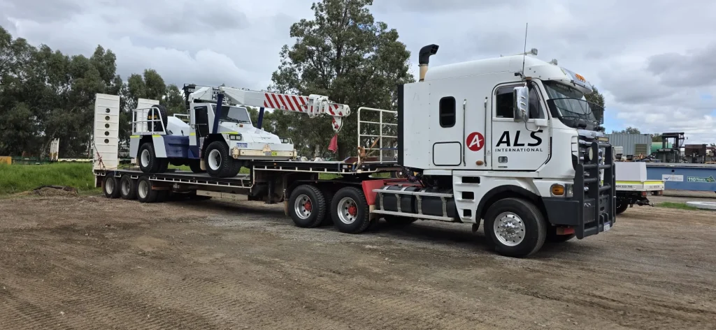 ALS International prime mover and float loaded with a pick-and-carry crane
