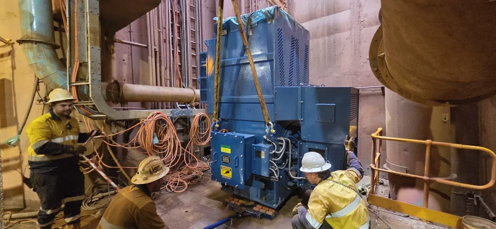 ALS International riggers craning a heavy electric motor into position at an industrial plant